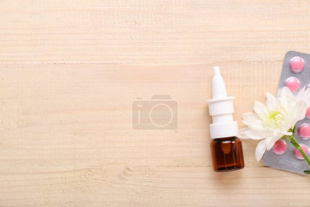 Photo for Nasal drops with flower and pills on light wooden background. Seasonal allergy concept - Royalty Free Image
