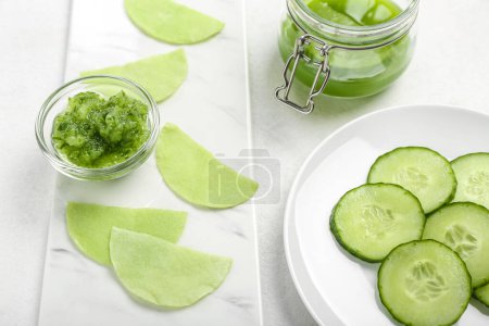 Photo for Cotton under-eye patches with cucumber slices on white table, closeup - Royalty Free Image