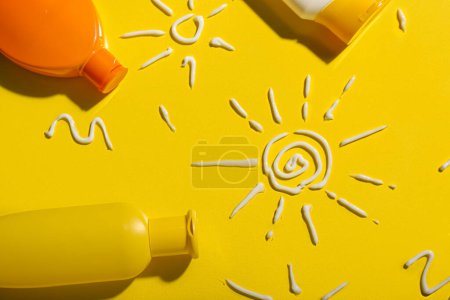 Téléchargez les photos : Dessins de soleils réalisés avec crème solaire sur fond jaune - en image libre de droit