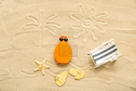 Foto de Composición creativa con crema protectora solar y accesorios de playa sobre arena - Imagen libre de derechos