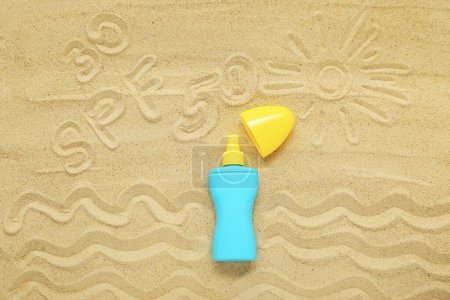 Foto de Composición creativa con crema protector solar y dibujos sobre arena - Imagen libre de derechos