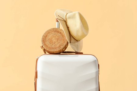Photo for Suitcase with summer hat and bag on beige background - Royalty Free Image