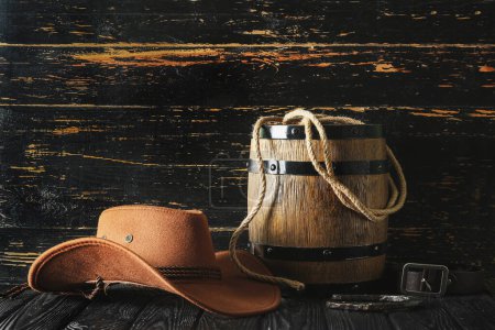 Sombrero vaquero, lazo y herradura sobre fondo de madera