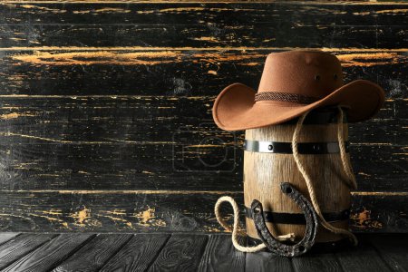 Cowboyhut, Lasso und Hufeisen auf Holzgrund