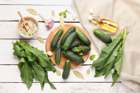 Photo for Board with fresh cucumbers and ingredients for preservation on light wooden background - Royalty Free Image
