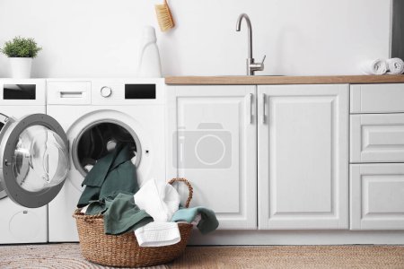 Photo for Modern washing machines with dirty clothes in laundry room - Royalty Free Image