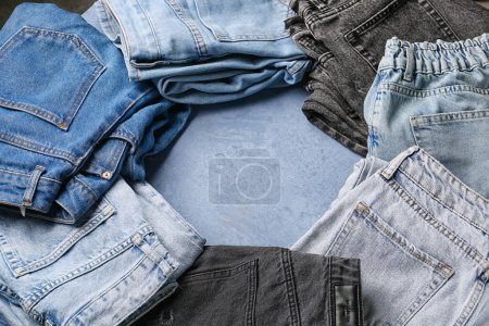Photo for Frame made of different stylish denim jeans on grunge blue background - Royalty Free Image