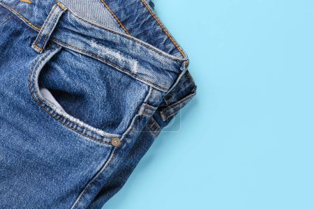 Téléchargez les photos : Jeans denim élégant sur fond bleu, gros plan - en image libre de droit