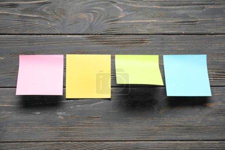 Photo for Sticky notes on black wooden background - Royalty Free Image