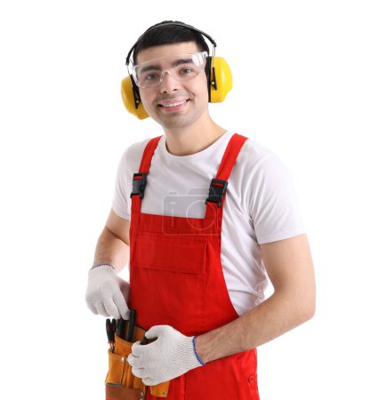 Foto de Joven carpintero en protectores auditivos con bolsa de herramientas sobre fondo blanco - Imagen libre de derechos