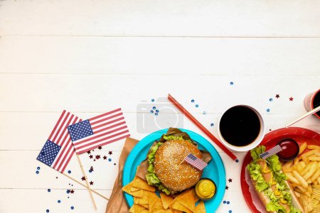 Composition avec plats savoureux, boissons et drapeaux américains en papier sur fond bois clair. Célébration commémorative