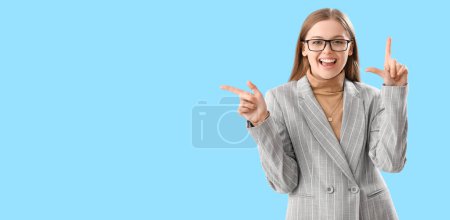 Foto de Joven empresaria sonriente mostrando gesto perdedor sobre fondo azul claro con espacio para texto - Imagen libre de derechos