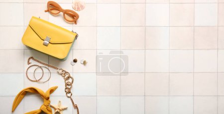 Stylish bag and female accessories on light tile background with space for text Poster 658543350