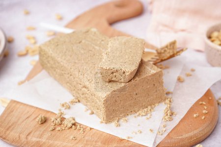 Photo for Board with tasty halva and peanuts on white background - Royalty Free Image