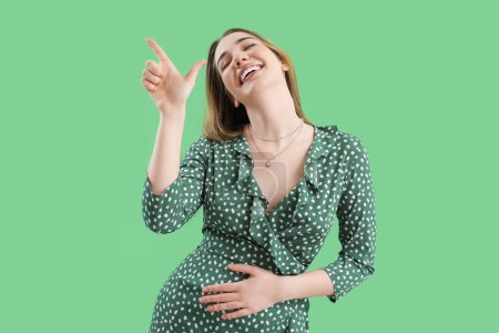 Photo for Young woman showing loser gesture on green background - Royalty Free Image