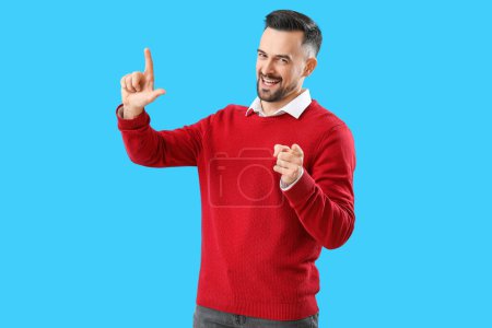 Photo for Handsome man showing loser gesture on blue background - Royalty Free Image