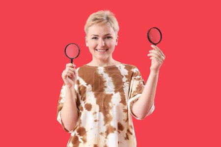 Photo for Young woman with magnifiers on red background - Royalty Free Image
