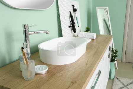 Téléchargez les photos : Comptoir avec vasque, brosses à dents et outils de coiffure sur pegboard dans la salle de bain - en image libre de droit