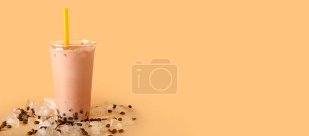 Photo for Plastic cup of tasty bubble tea with coffee beans and ice cubes on beige background with space for text - Royalty Free Image