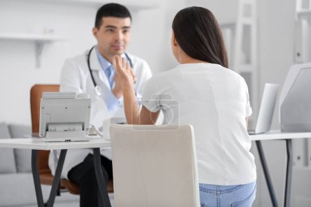 Photo for Young woman with bad posture visiting doctor in clinic - Royalty Free Image