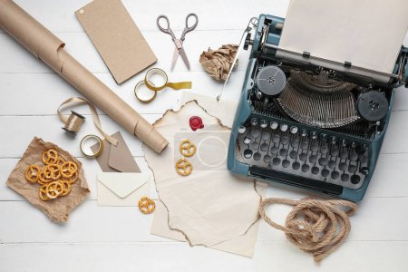 Téléchargez les photos : Composition avec machine à écrire vintage, parchemins, snacks et ciseaux sur table en bois blanc - en image libre de droit