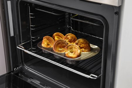 Photo for Baking tin with tasty Yorkshire pudding in oven - Royalty Free Image