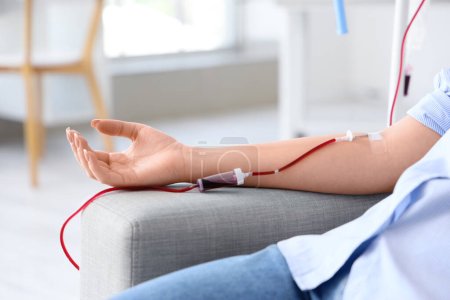 Young woman donating blood in clinic, closeup