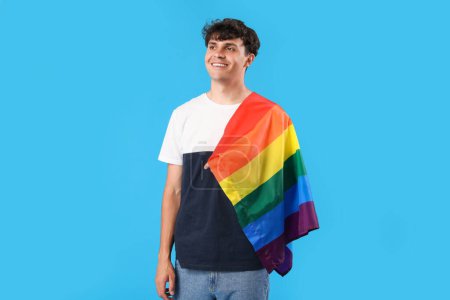 Joven con bandera LGBT sobre fondo azul