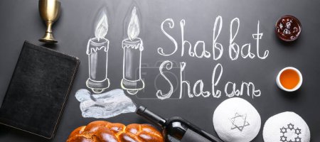 Drawn glowing candles, written text SHABBAT SHALOM, challah bread, wine, Tanakh and Jewish caps on chalkboard