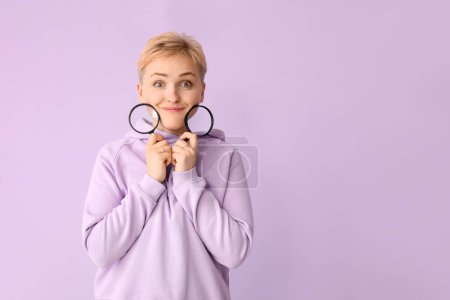 Photo for Young woman with magnifiers on lilac background - Royalty Free Image