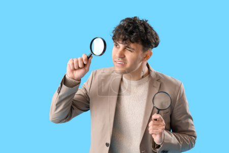 Photo for Young man with magnifiers on blue background - Royalty Free Image