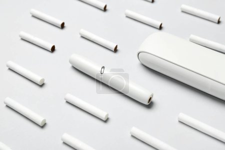 Téléchargez les photos : Cigare électronique moderne et de nombreux bâtons sur fond gris - en image libre de droit