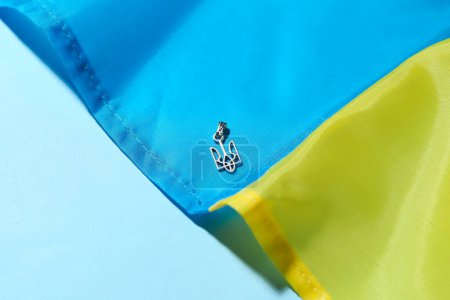 Foto de Colgante con escudo de armas ucraniano y bandera sobre fondo azul, primer plano - Imagen libre de derechos