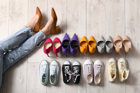 Piernas femeninas con diferentes zapatos elegantes en el suelo
