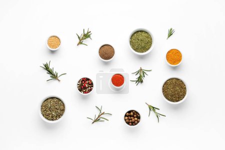 Photo for Composition with bowls of different spices and rosemary on light background - Royalty Free Image