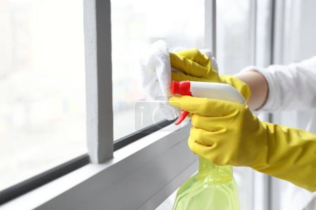 Photo for Housewife cleaning window with rag at home, closeup - Royalty Free Image