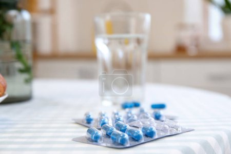Folic Acid pills on dining table in kitchen, closeup
