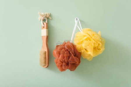 Photo for Bath loofahs with massage brush hanging on green wall - Royalty Free Image