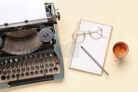 Foto de Máquina de escribir vintage con hoja de papel en blanco, vasos, cuaderno, lápiz y taza de café sobre fondo amarillo - Imagen libre de derechos
