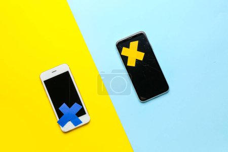 Photo for Mobile phones with adhesive tapes on color background - Royalty Free Image