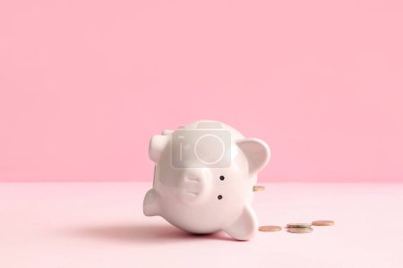 Foto de Hucha con dinero sobre fondo rosa. Concepto de quiebra - Imagen libre de derechos