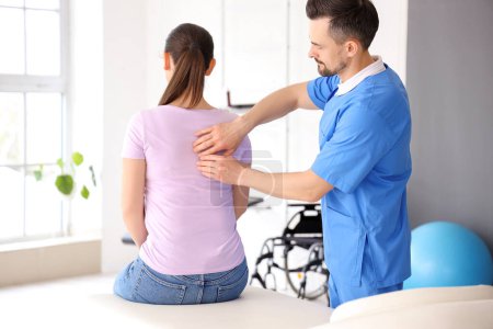 Photo for Male physiotherapist working with young woman in rehabilitation center - Royalty Free Image