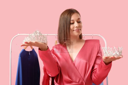 Photo for Young woman with tiaras for prom on pink background - Royalty Free Image