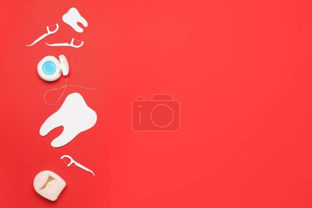 Foto de Hilo dental, mondadientes y modelo de dientes sobre fondo rojo - Imagen libre de derechos