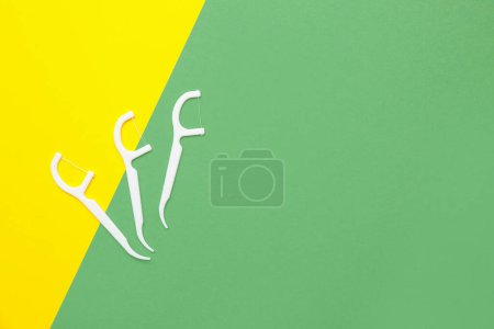 Photo for Floss toothpicks on yellow and green background - Royalty Free Image