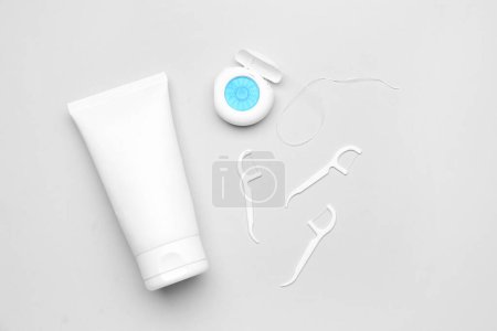Foto de Hilo dental, mondadientes y tubo de pasta de dientes sobre fondo gris - Imagen libre de derechos