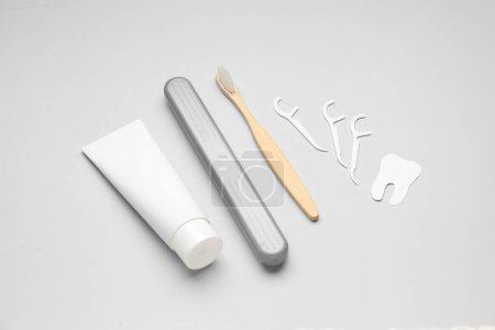 Photo for Floss toothpicks, tube of paste, brush and tooth model on grey background - Royalty Free Image