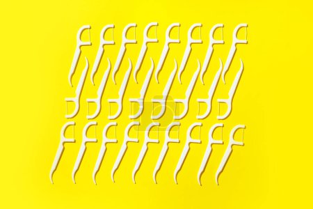 Foto de Muchos palillos de dientes de hilo dental sobre fondo amarillo - Imagen libre de derechos