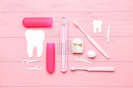 Foto de Composición con hilo dental, mondadientes y cepillos sobre fondo de madera rosa - Imagen libre de derechos