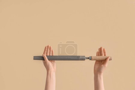 Photo for Female hands holding rasp on beige background - Royalty Free Image